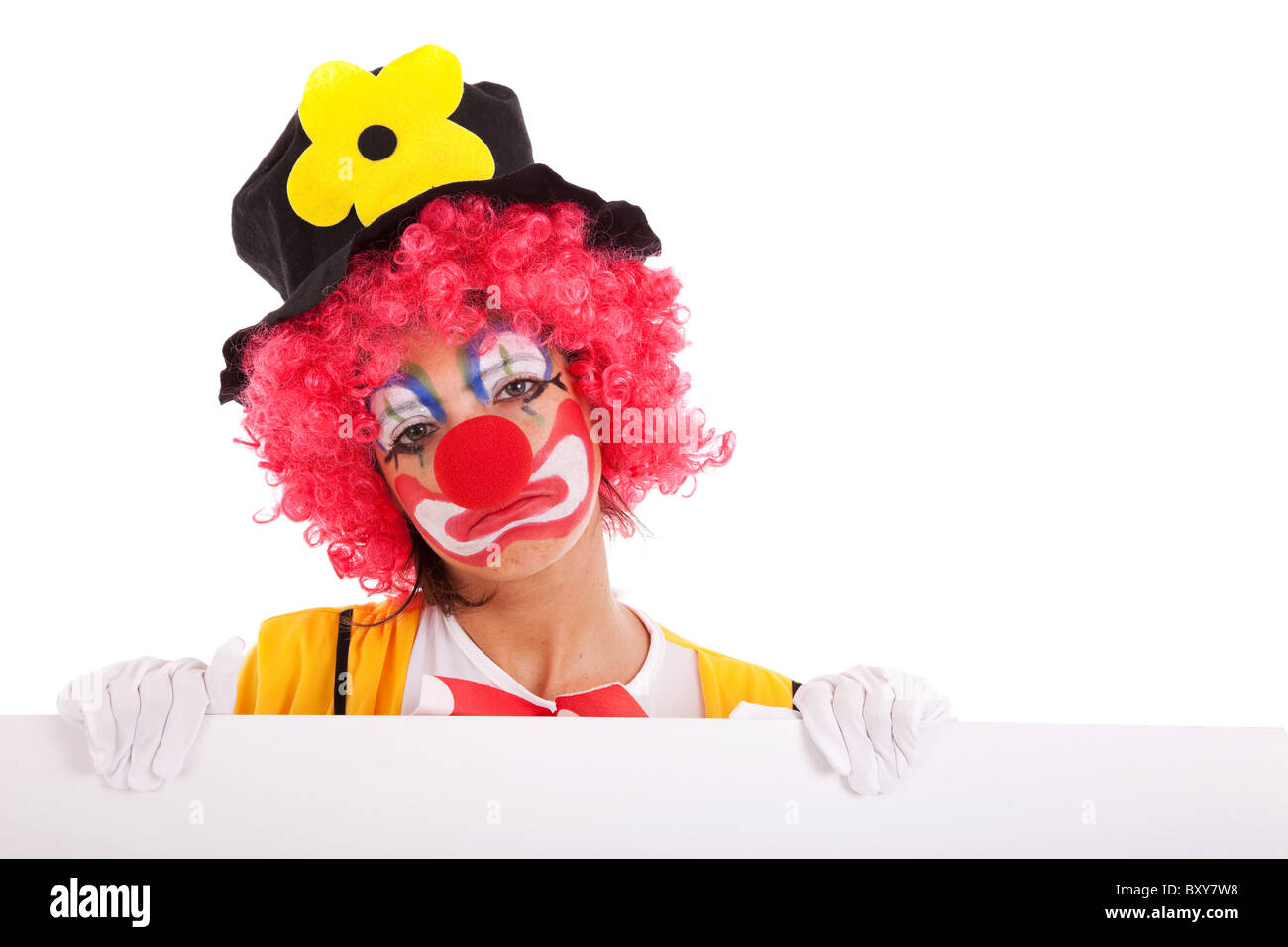 Triste clown tenendo un'intestazione vuota (isolato su bianco) Foto Stock