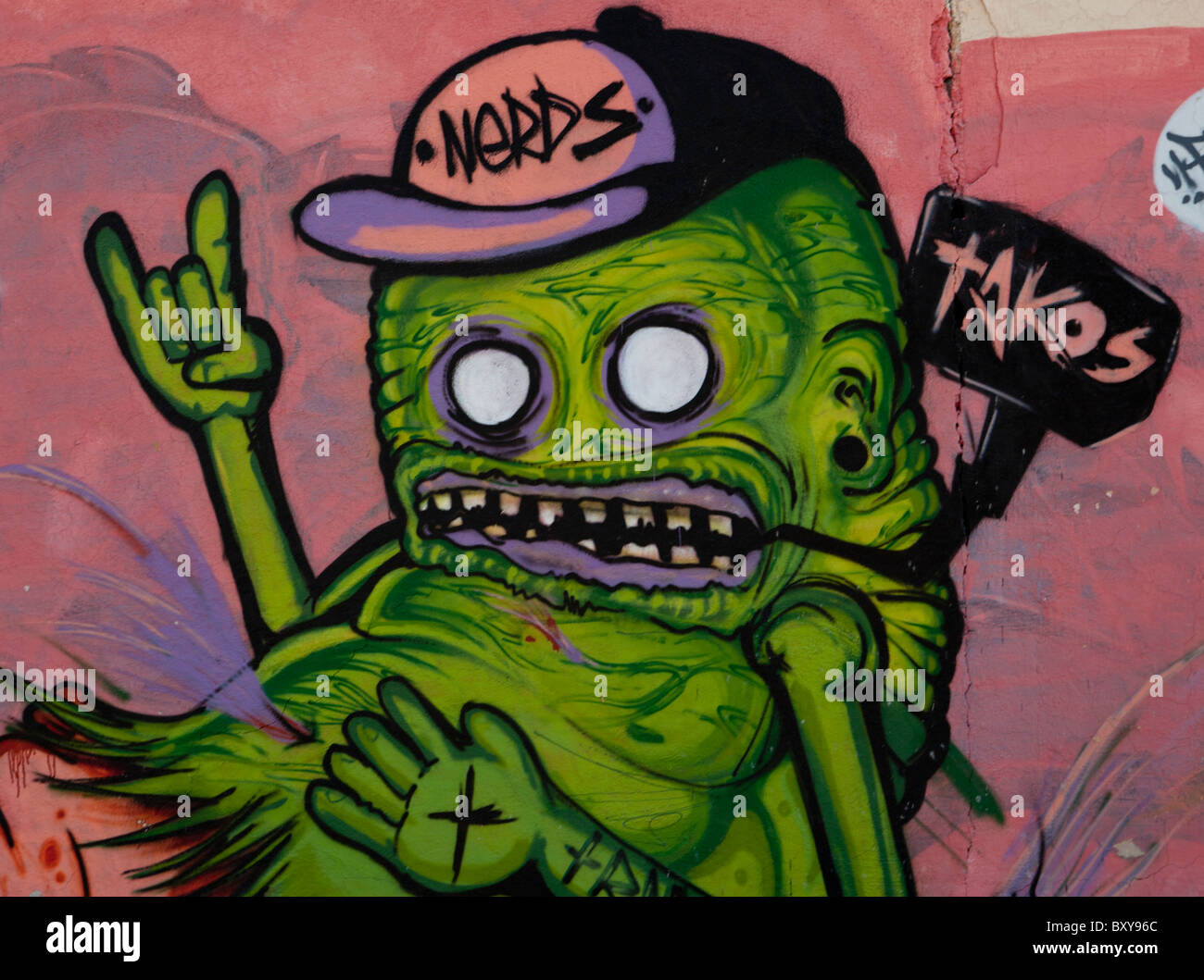 Carta murale raffigurante un mostro verde lungo una strada in stile coloniale spagnolo città di Santiago di Querétaro, Queretaro, Messico Foto Stock