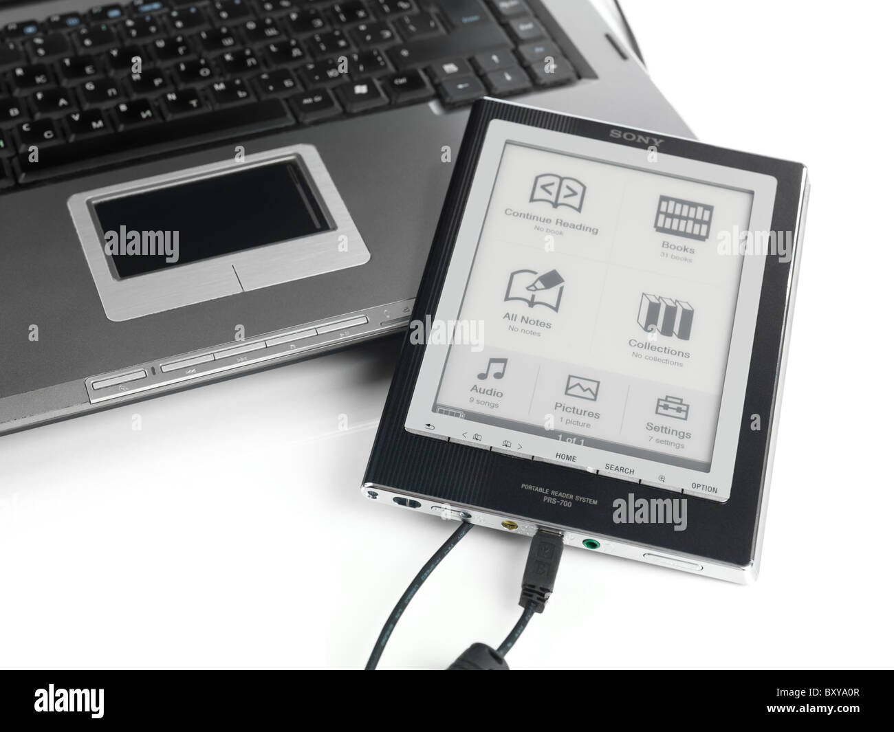 Sony Lettore collegato a un computer portatile tramite USB. PRS-700 Lettore portatile sistema. Isolato su sfondo bianco. Foto Stock