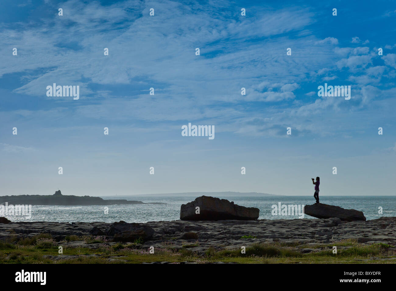 Donna prendendo le fotografie delle isole di Arran a Doolin località turistica, County Clare, costa Ovest dell Irlanda Foto Stock