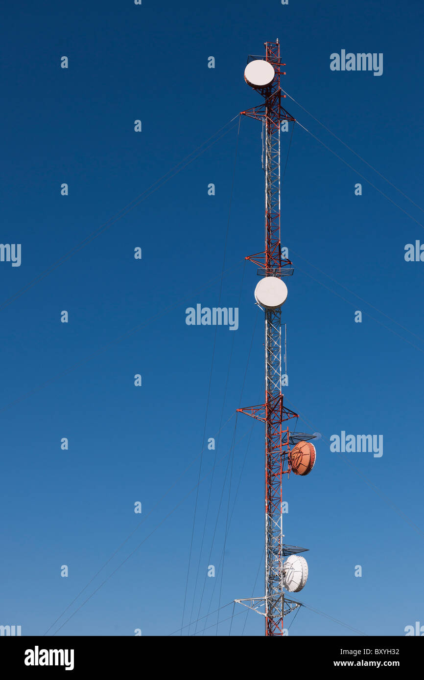 Tele-relè di comunicazioni torre contro il cielo blu Foto Stock