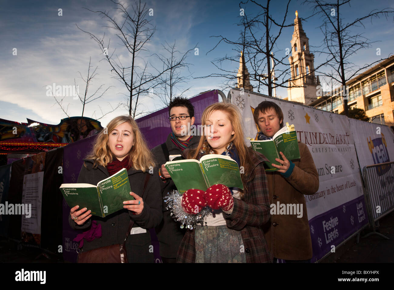 Regno Unito, Inghilterra, Yorkshire, Leeds, Millennium Square, il collegio di studenti di musica a cantare i canti natalizi Foto Stock