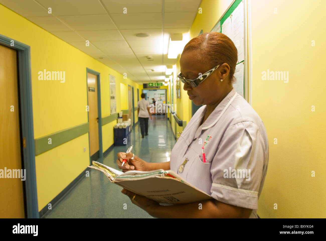 Un infermiere controlla i record in un corridoio di ospedale REGNO UNITO Foto Stock