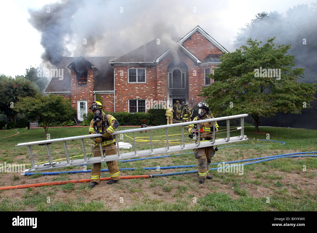 I vigili del fuoco di mettere fuori un tripudio di 2 story house. Foto Stock