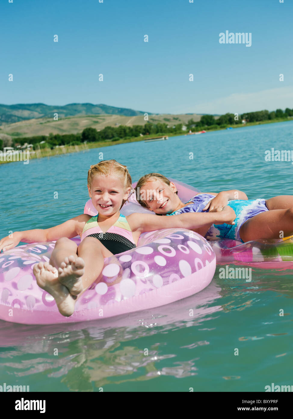 Ragazze galleggiante su dei giocattoli gonfiabili Foto Stock