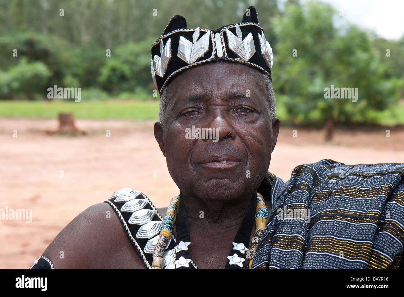 Un capo locale della piccola minoranza gruppo di persone adornato con corona e altri atrapments rispondente alla royalty rurale in Africa occidentale. Foto Stock