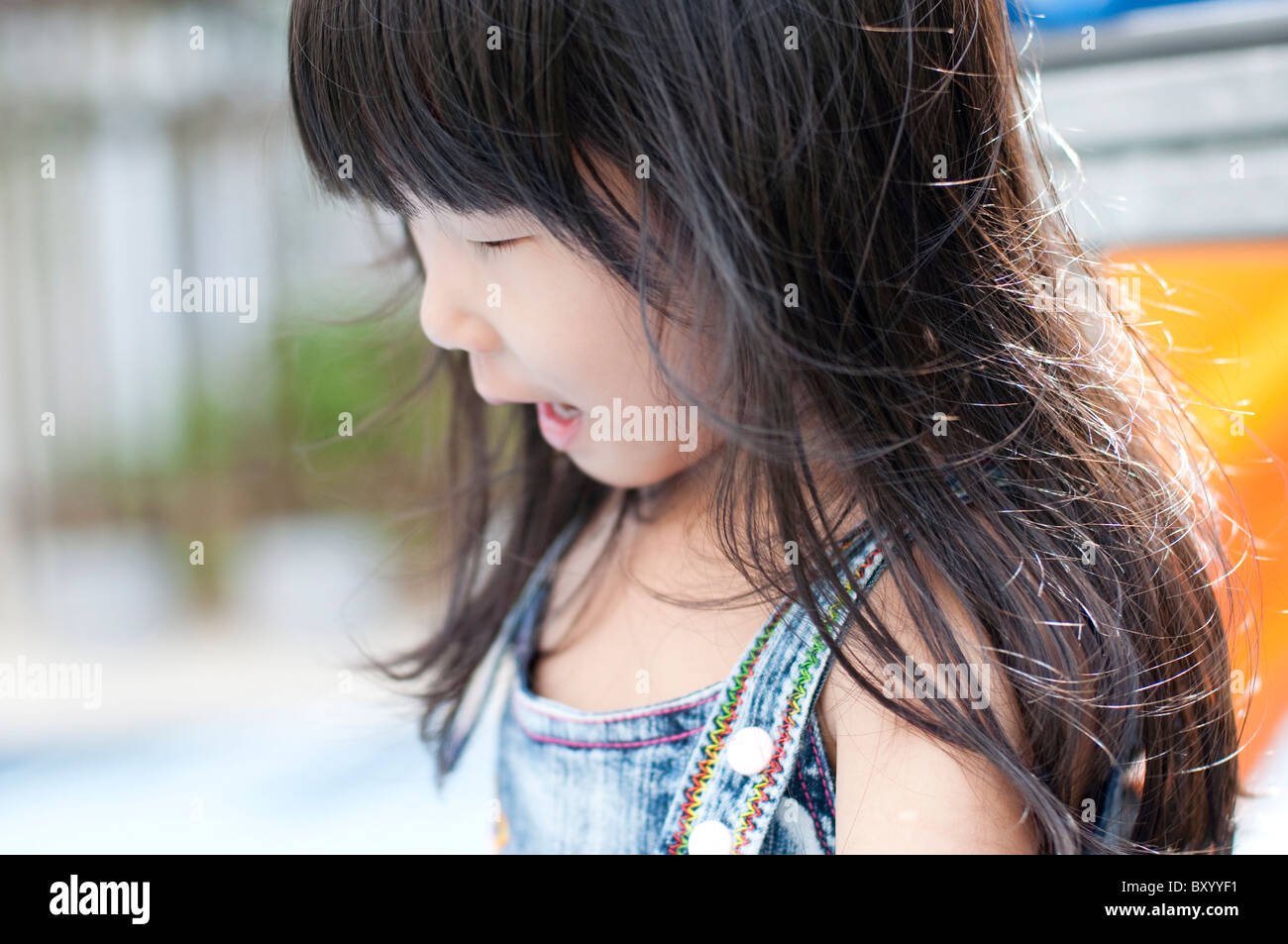 Candide momento di poco ragazza asiatica divertirsi nel parco giochi. Foto Stock