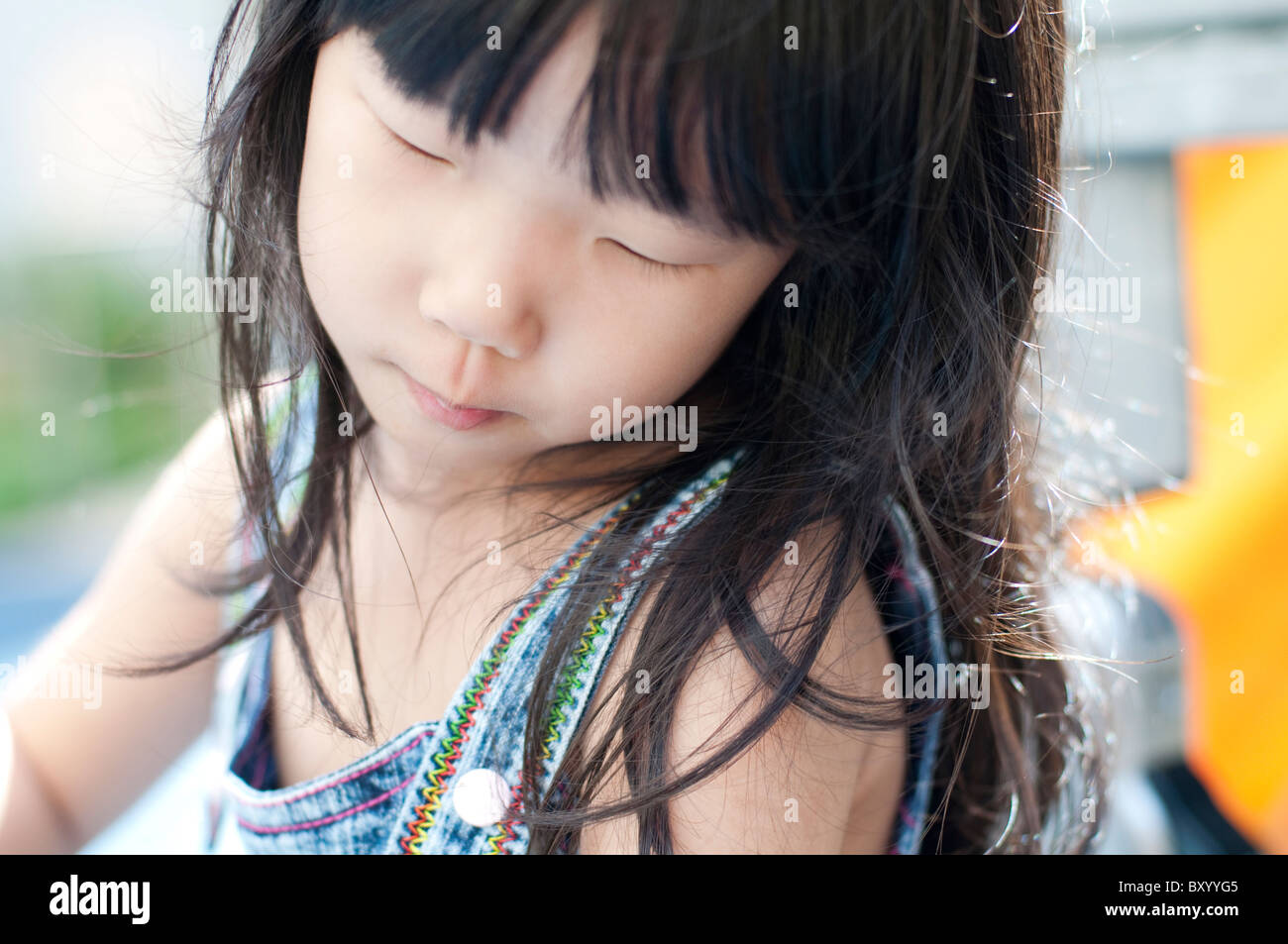 Candide momento di poco ragazza asiatica divertirsi nel parco giochi. Foto Stock