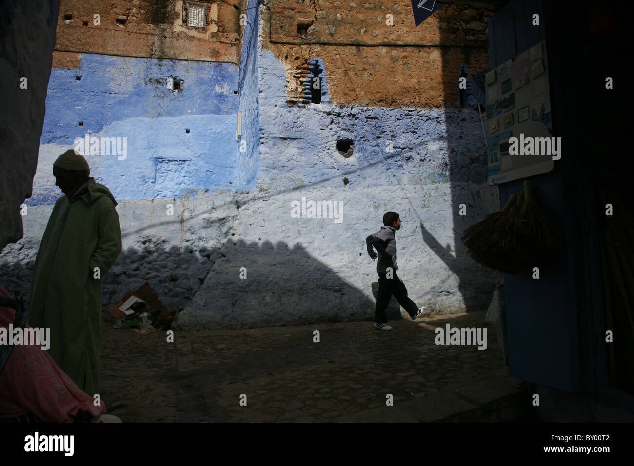 La popolazione locale a piedi intorno al luminoso strade di chefchaouen il luminoso marocco villaggio nelle montagne di riff Foto Stock