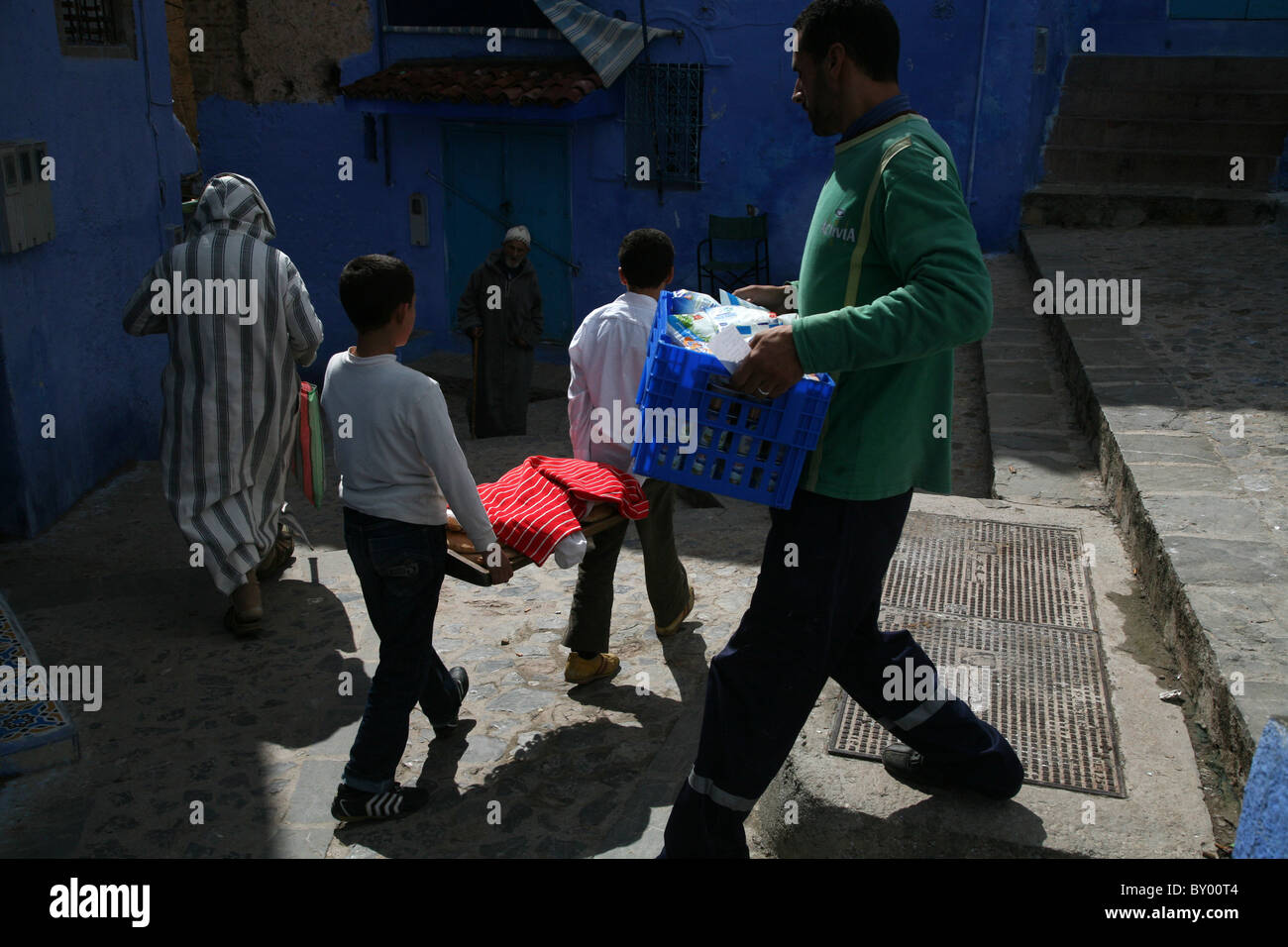 La popolazione locale a piedi intorno al luminoso strade di chefchaouen il luminoso marocco villaggio nelle montagne di riff Foto Stock