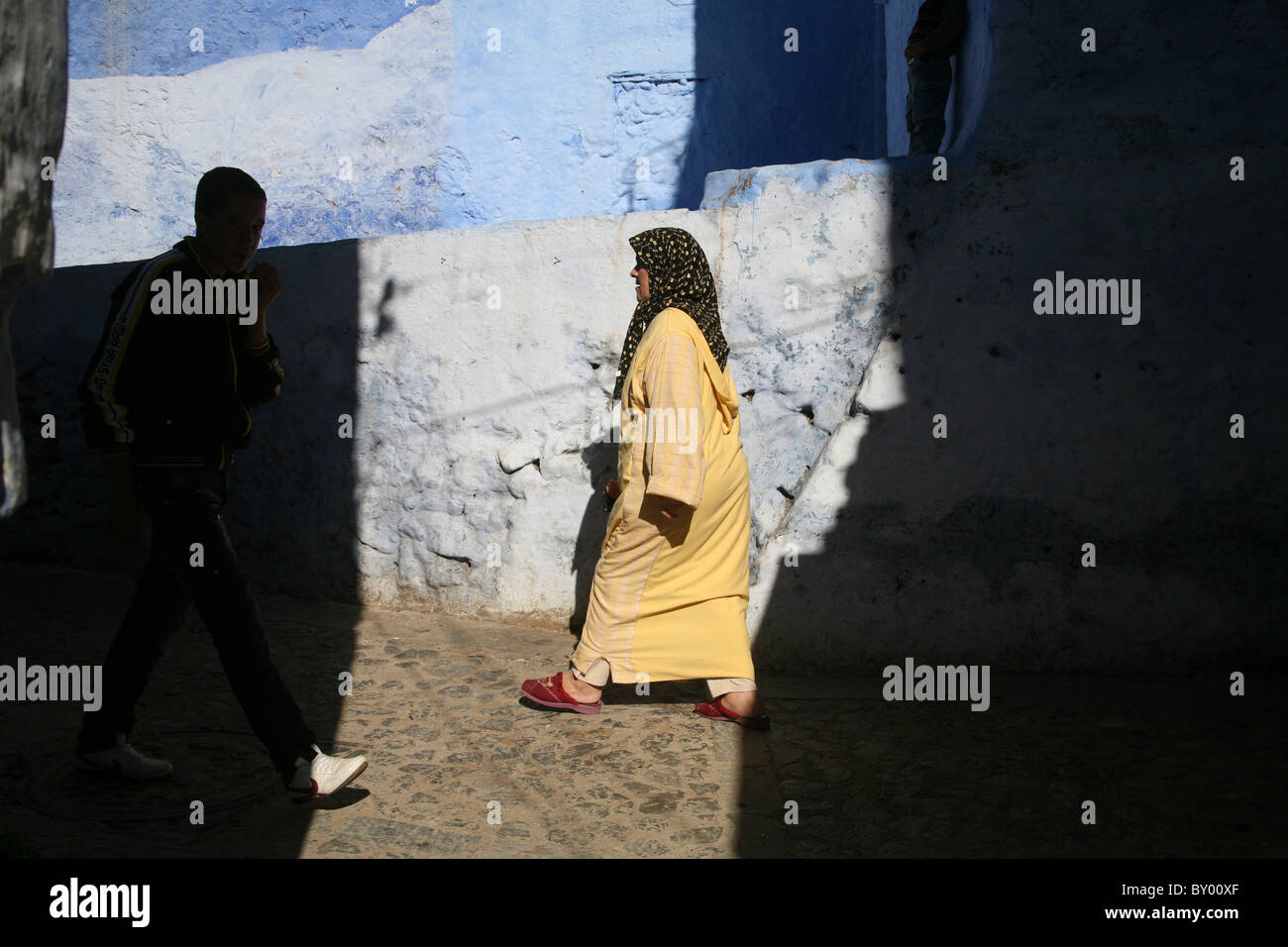 La popolazione locale a piedi intorno al luminoso strade di chefchaouen il luminoso marocco villaggio nelle montagne di riff Foto Stock