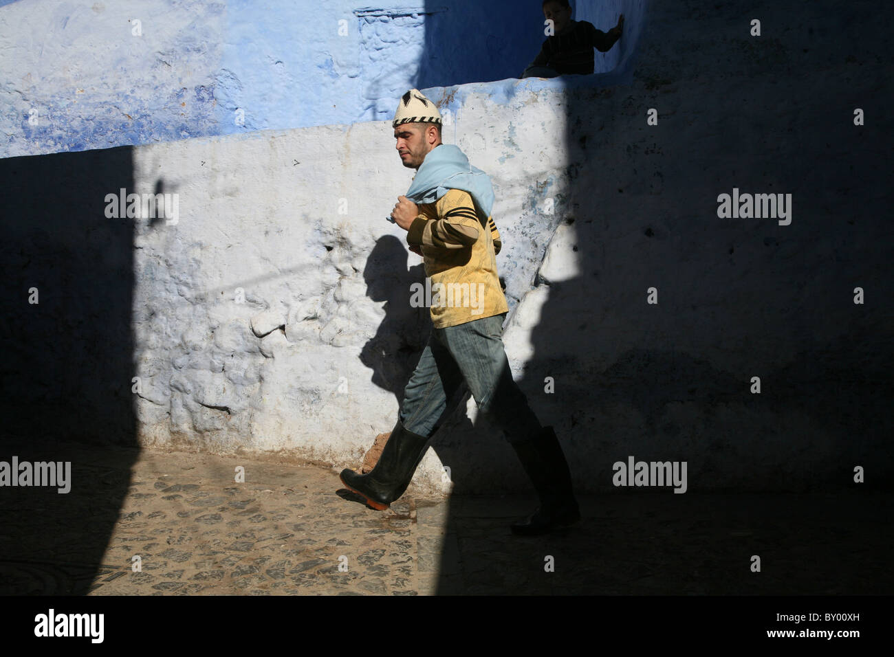 La popolazione locale a piedi intorno al luminoso strade di chefchaouen il luminoso marocco villaggio nelle montagne di riff Foto Stock