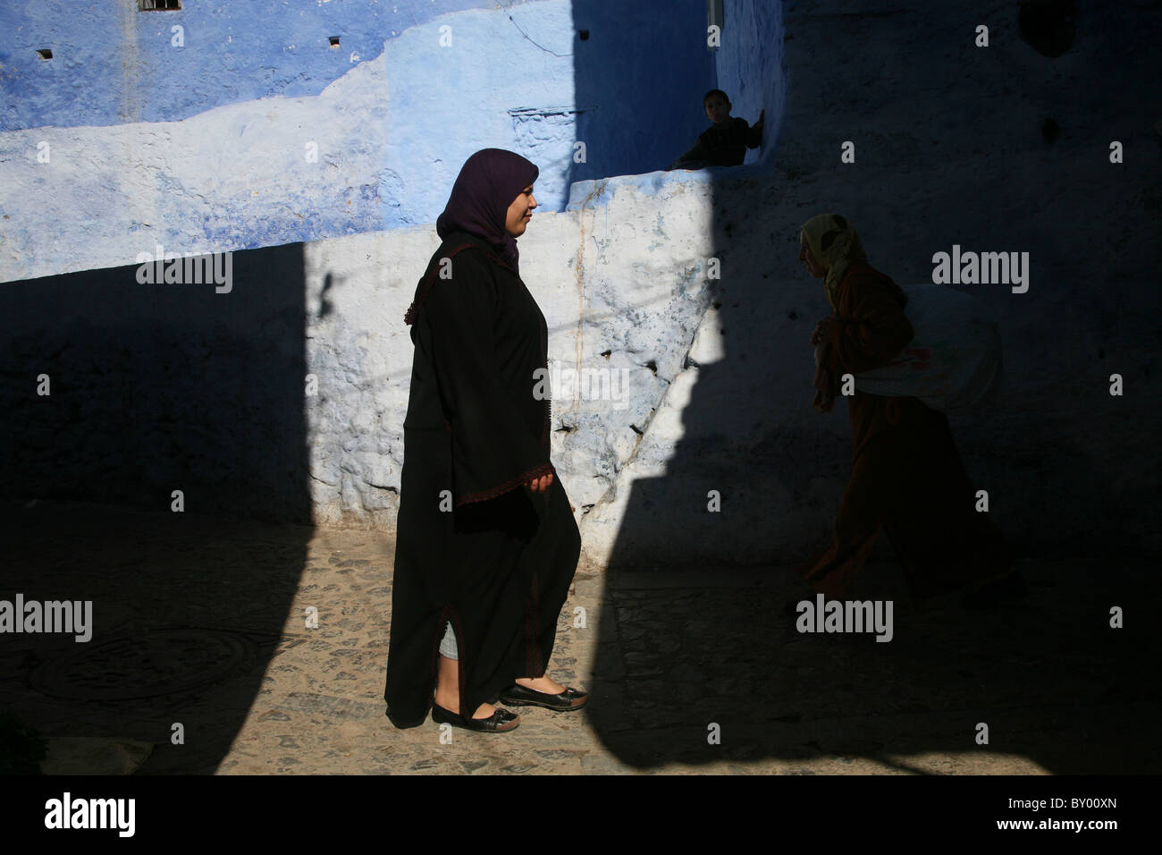 La popolazione locale a piedi intorno al luminoso strade di chefchaouen il luminoso marocco villaggio nelle montagne di riff Foto Stock