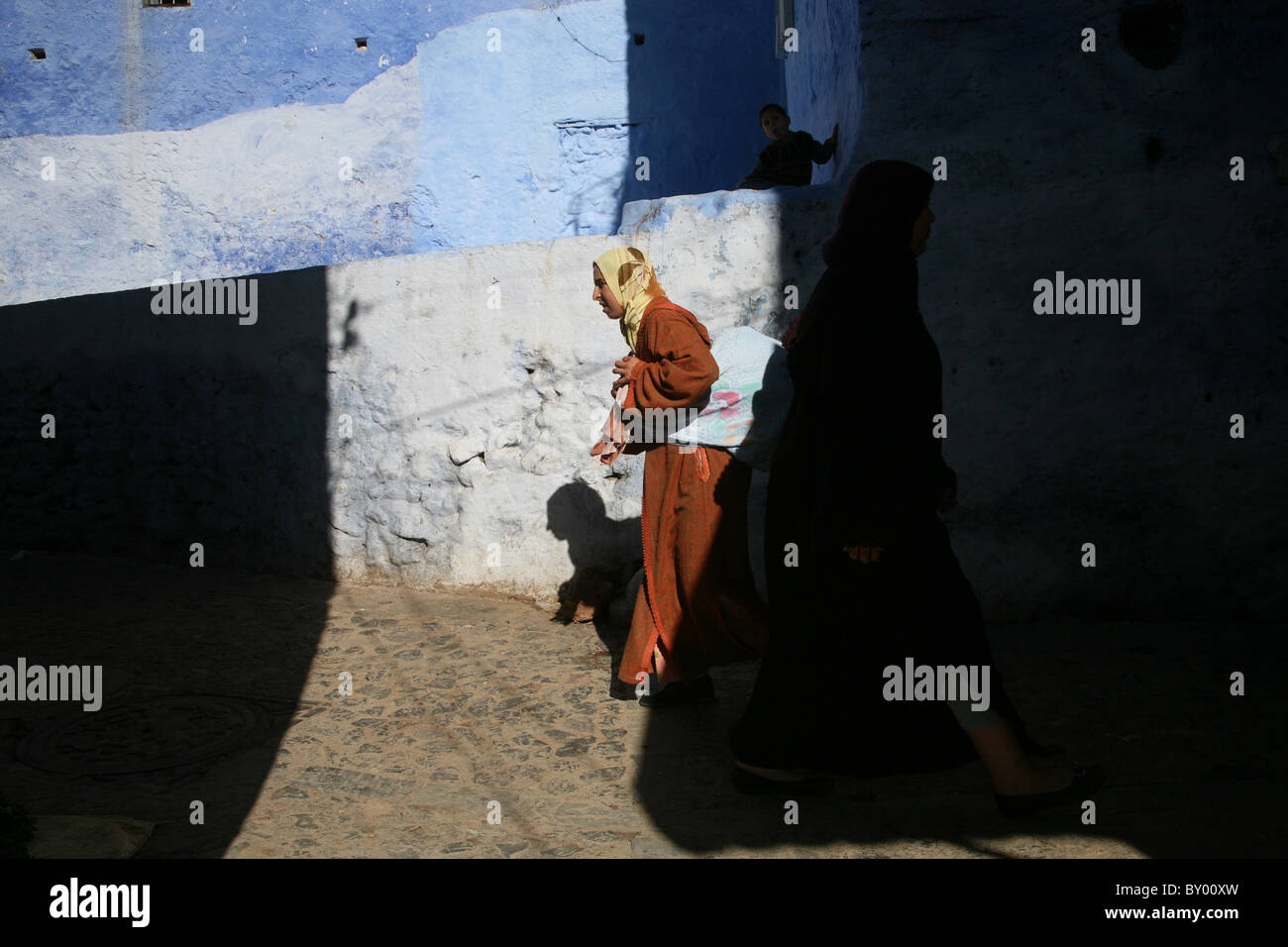 La popolazione locale a piedi intorno al luminoso strade di chefchaouen il luminoso marocco villaggio nelle montagne di riff Foto Stock