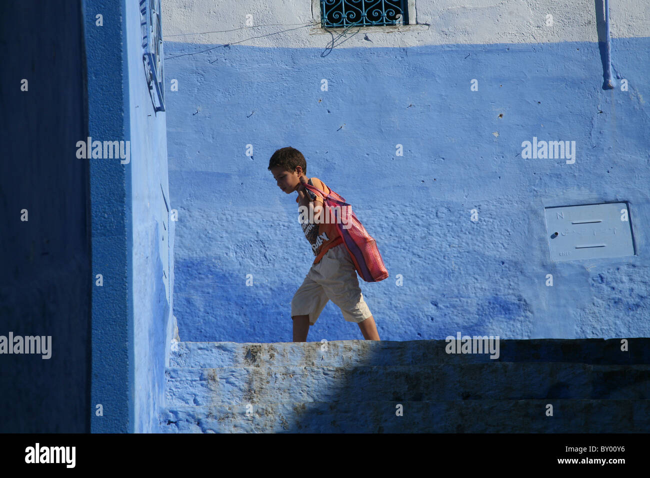 La popolazione locale a piedi intorno al luminoso strade di chefchaouen il luminoso marocco villaggio nelle montagne di riff Foto Stock