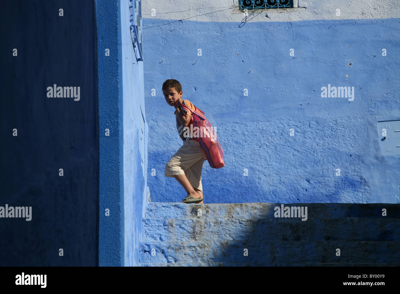 La popolazione locale a piedi intorno al luminoso strade di chefchaouen il luminoso marocco villaggio nelle montagne di riff Foto Stock