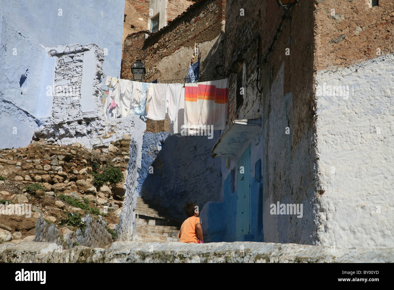La popolazione locale a piedi intorno al luminoso strade di chefchaouen il luminoso marocco villaggio nelle montagne di riff Foto Stock