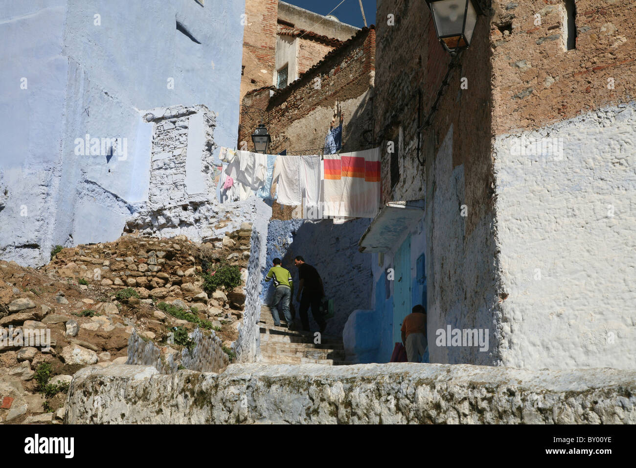 La popolazione locale a piedi intorno al luminoso strade di chefchaouen il luminoso marocco villaggio nelle montagne di riff Foto Stock