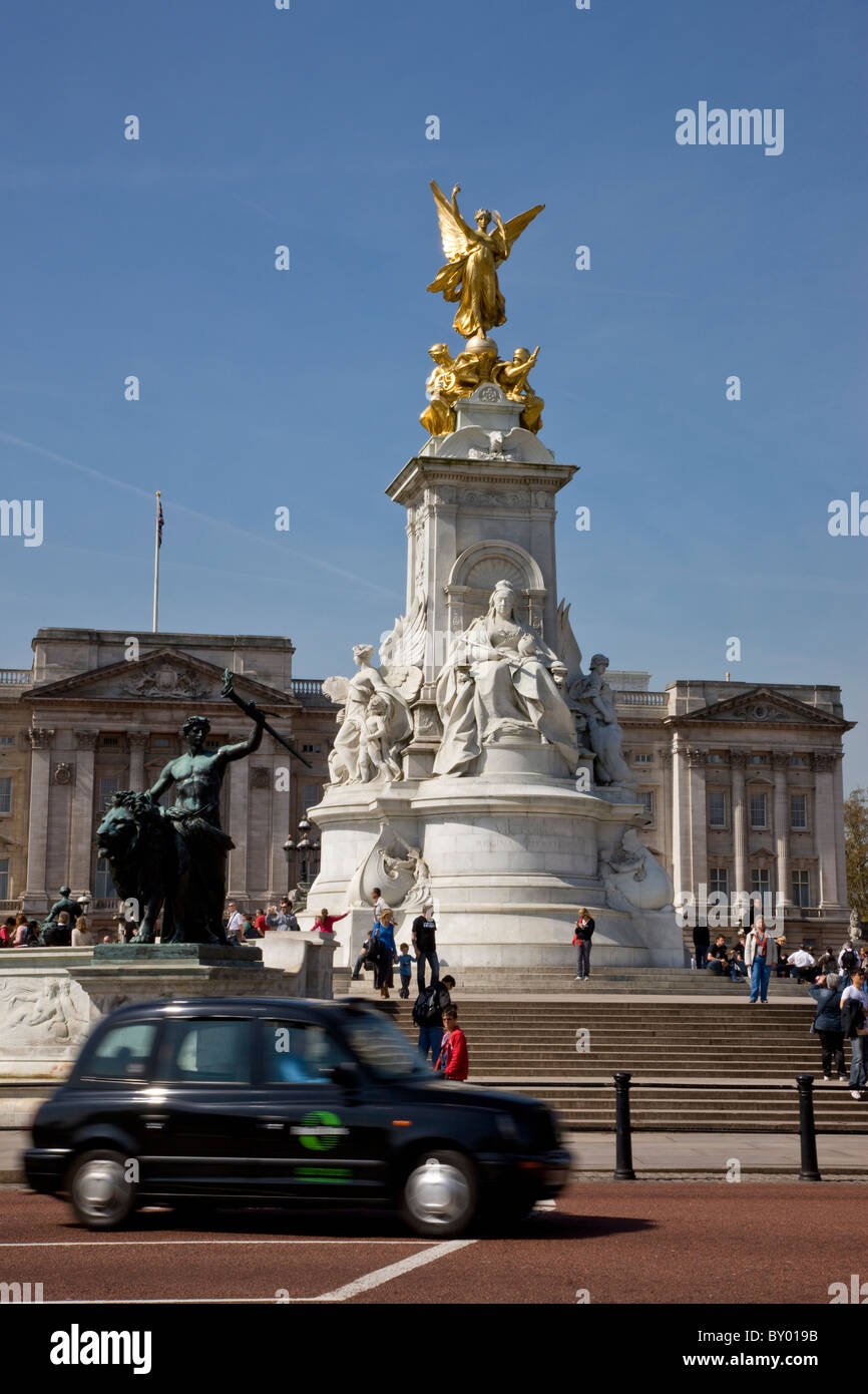 Taxi passando la regina Victoria Memorial di fronte a Buckingham Palace Foto Stock