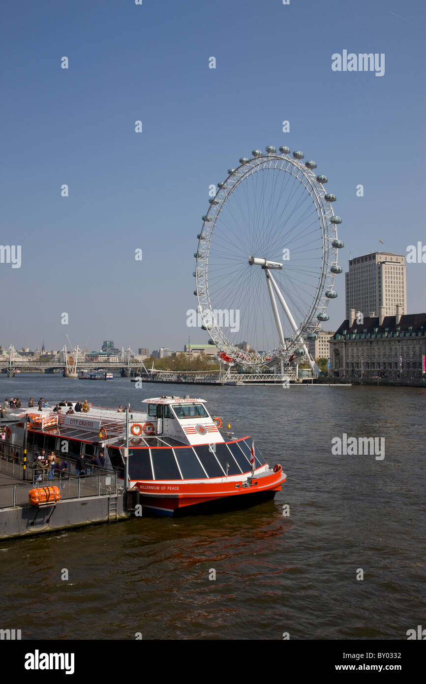 Battello da crociera sul Tamigi da Westminster Bridge con il London Eye in background Foto Stock
