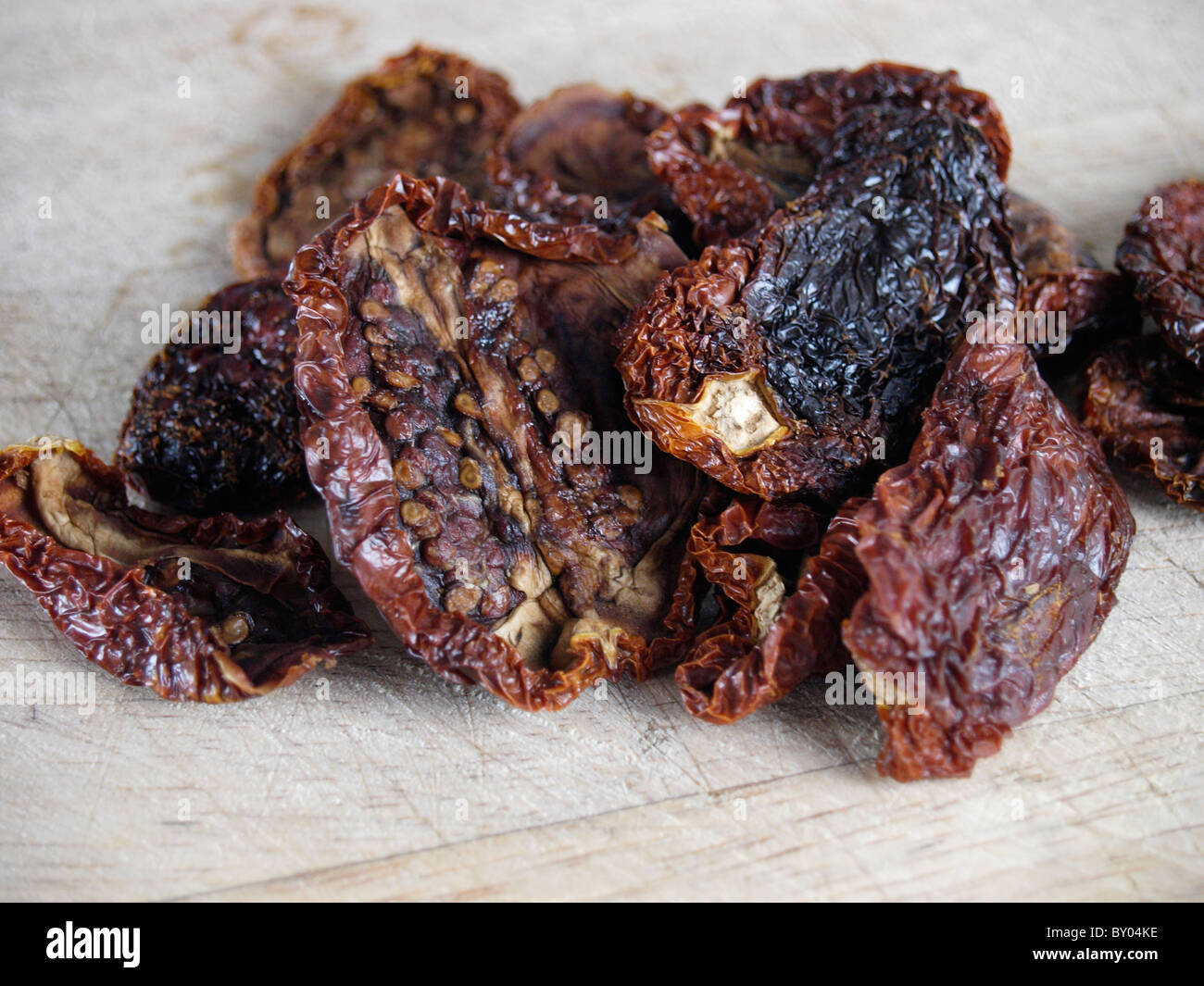 Pomodori seccati al sole su di un tagliere Foto Stock
