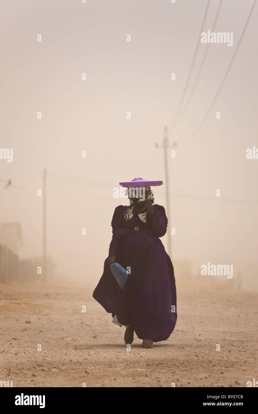 Herero donna in tempesta di polvere, Opuwo, Namibia Foto Stock