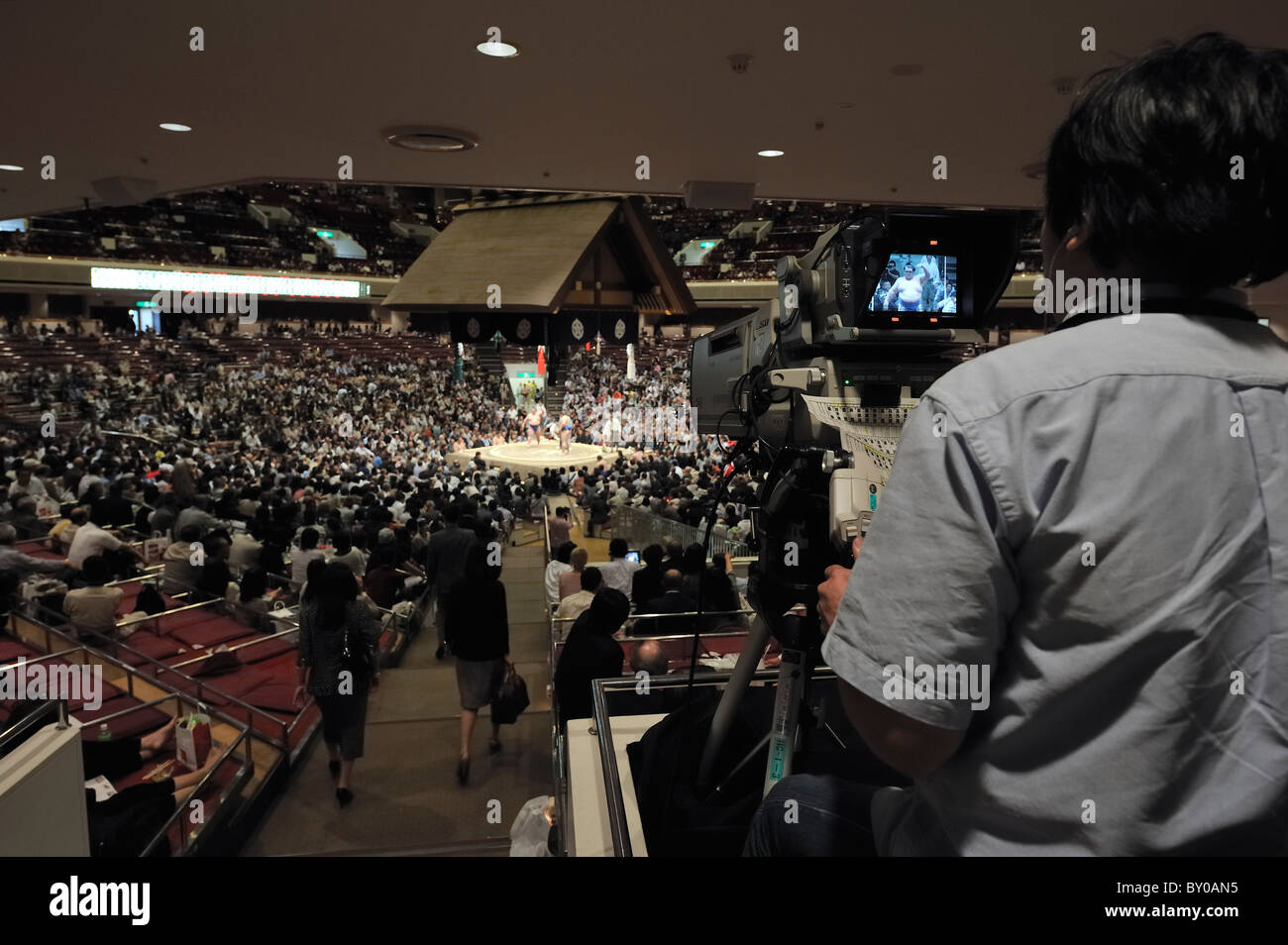 Cameraman rendendo un close-up dell'anello, Grandi Campionati di Sumo maggio 2010, Ryogoku Kokugikan, Tokyo, Giappone Foto Stock