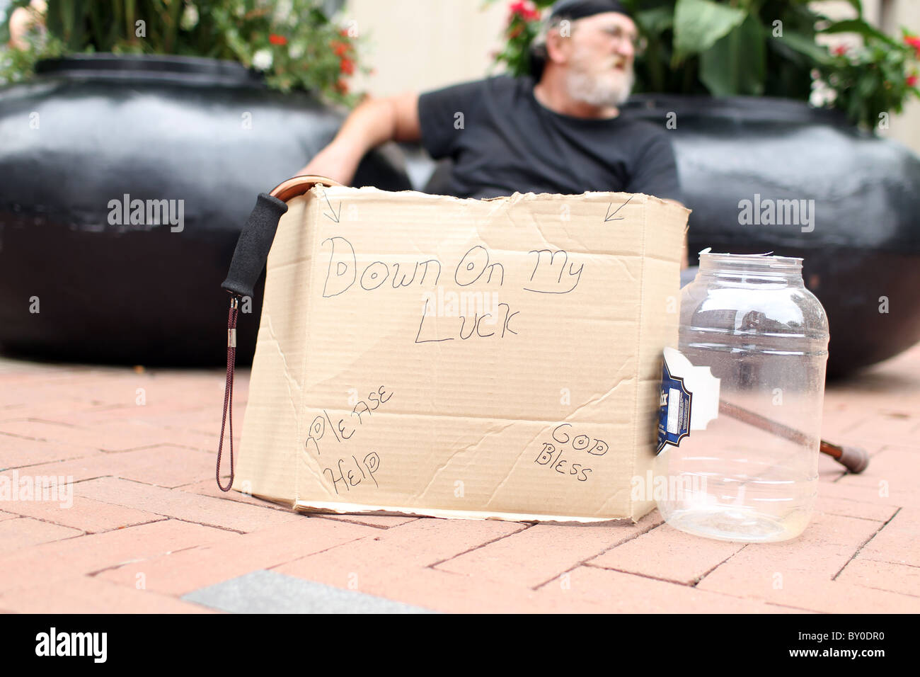 Un senzatetto si siede e implora per modificare in tempi di crisi economica sul centro commerciale di Charlottesville, Virginia. Foto Stock