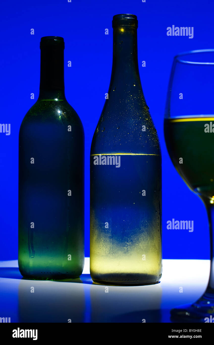 Magazzino-style foto, refrigerate le bottiglie di vino con wineglass in primo piano. Le etichette possono essere aggiunti. Foto Stock