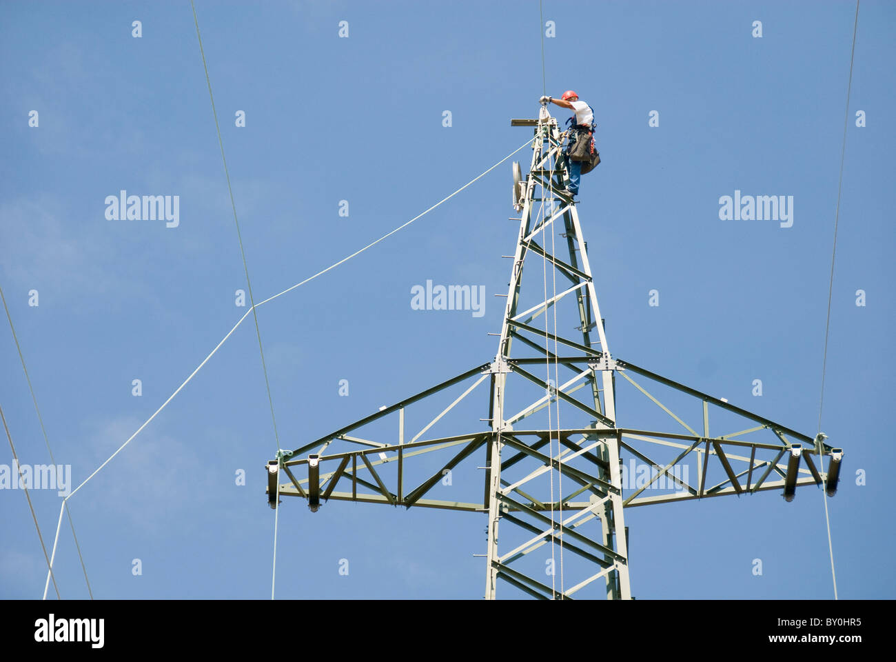 Lavoratore su un traliccio di elettricità di attaccare il cavo, Austria, Europa Foto Stock