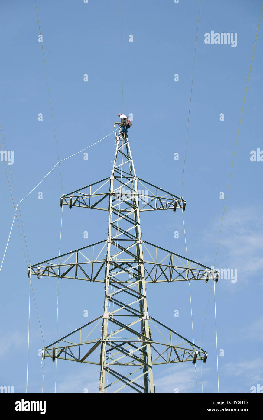 Lavoratore su un traliccio di elettricità di attaccare il cavo, Austria, Europa Foto Stock