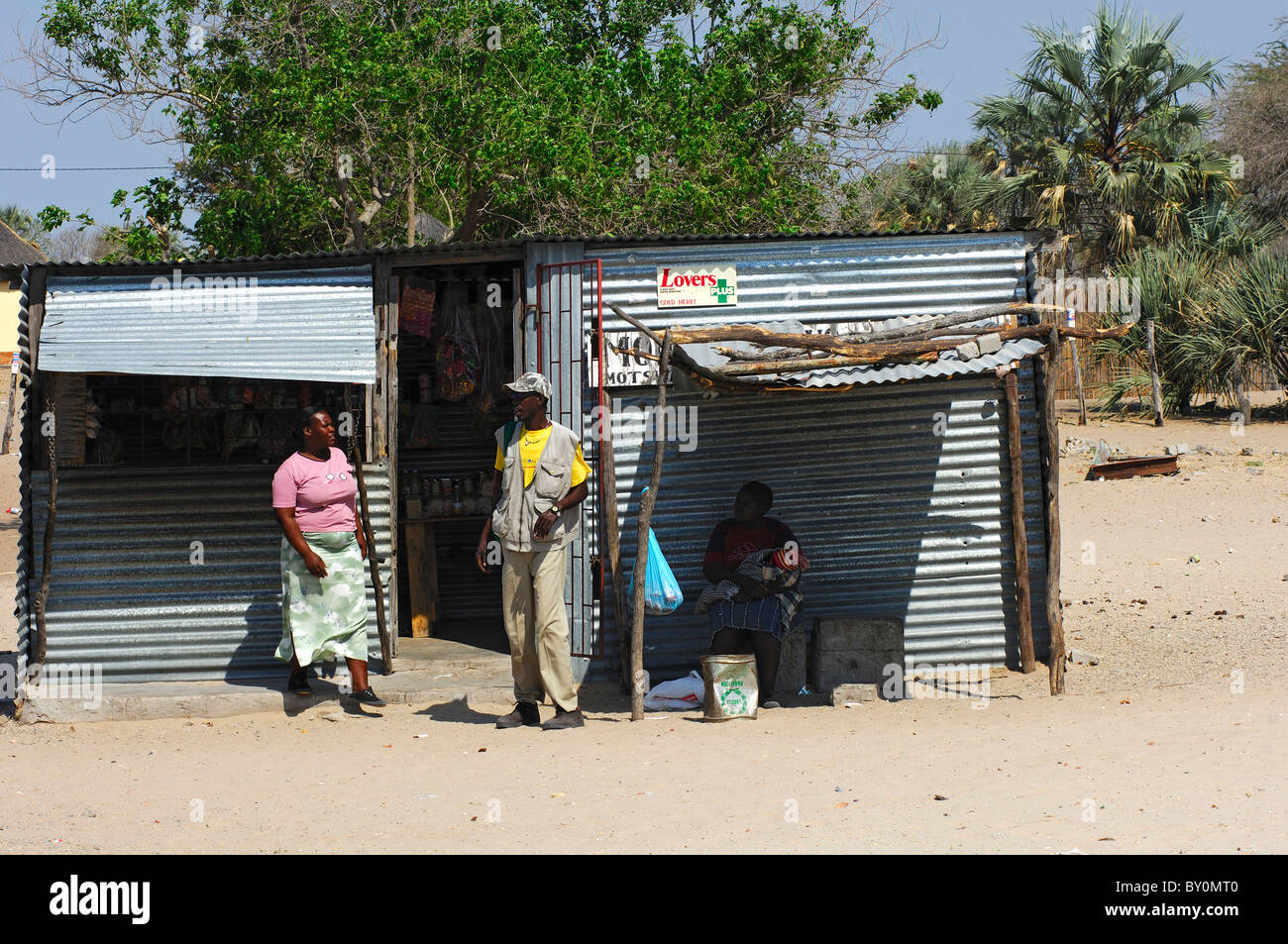 I client a una necessità quotidiane Store fatta di ferro corrugato in un villaggio Africano, Botswana Foto Stock