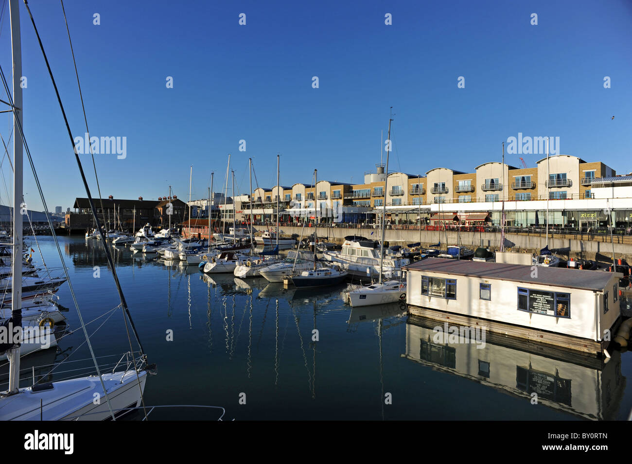 Barche ormeggiate in Brighton Marina come il sole comincia a impostare Foto Stock
