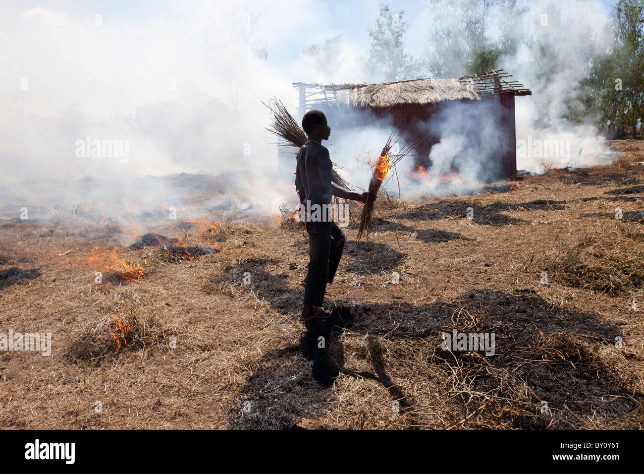 MUECATE quartiere vicino a Nampula, Mozambico, Maggio 2010 : il lavoratore agricolo brucia stoppie off e di erba in una fattoria. Foto Stock