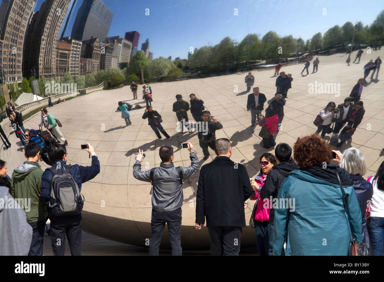 I visitatori guardano la loro riflessione nel Cloud Gate scultura si trova presso l'AT&T Plaza in Millennium Park di Chicago, Illinois. Foto Stock