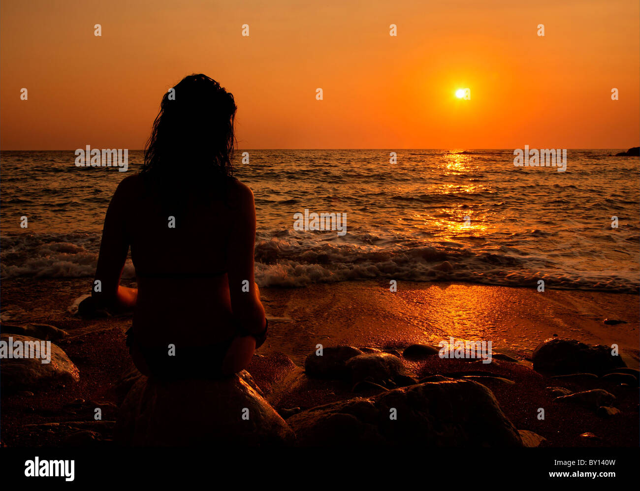 Un solitario lady godendo del tramonto, a Lycodemus beach, Cythera (o 'Kithira') Island, Grecia. Foto Stock