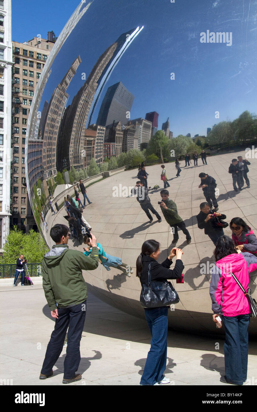 I visitatori guardano la loro riflessione nel Cloud Gate scultura si trova presso l'AT&T Plaza in Millennium Park di Chicago, Illinois. Foto Stock