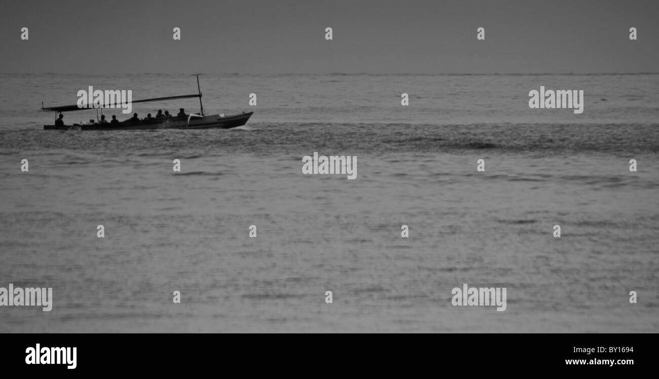 Barca da pesca di cavalcare le onde di Bali Foto Stock