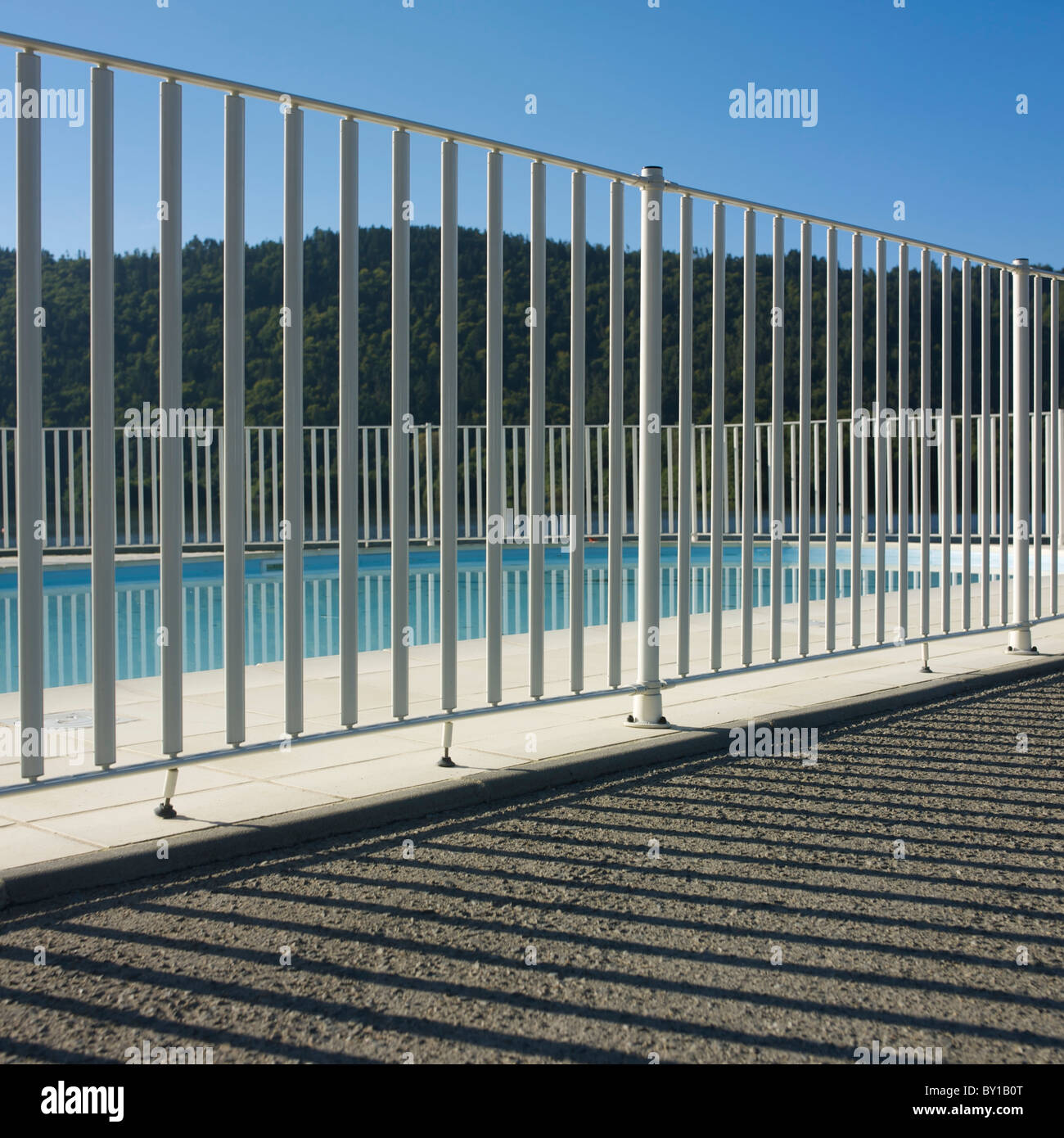 Soleggiata vista sulla piscina con ringhiere bianche e scenografico sfondo collinare vicino all'acqua Foto Stock