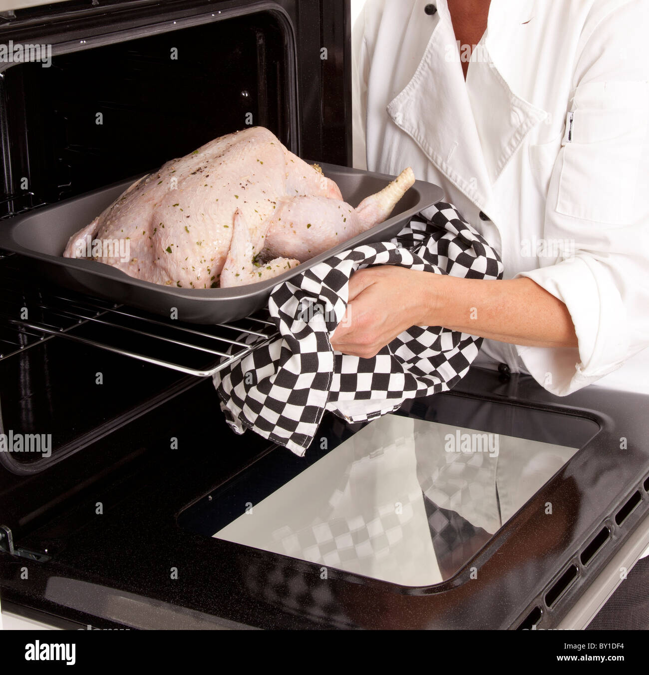 CHEF di mettere il pollo crudo in forno Foto Stock