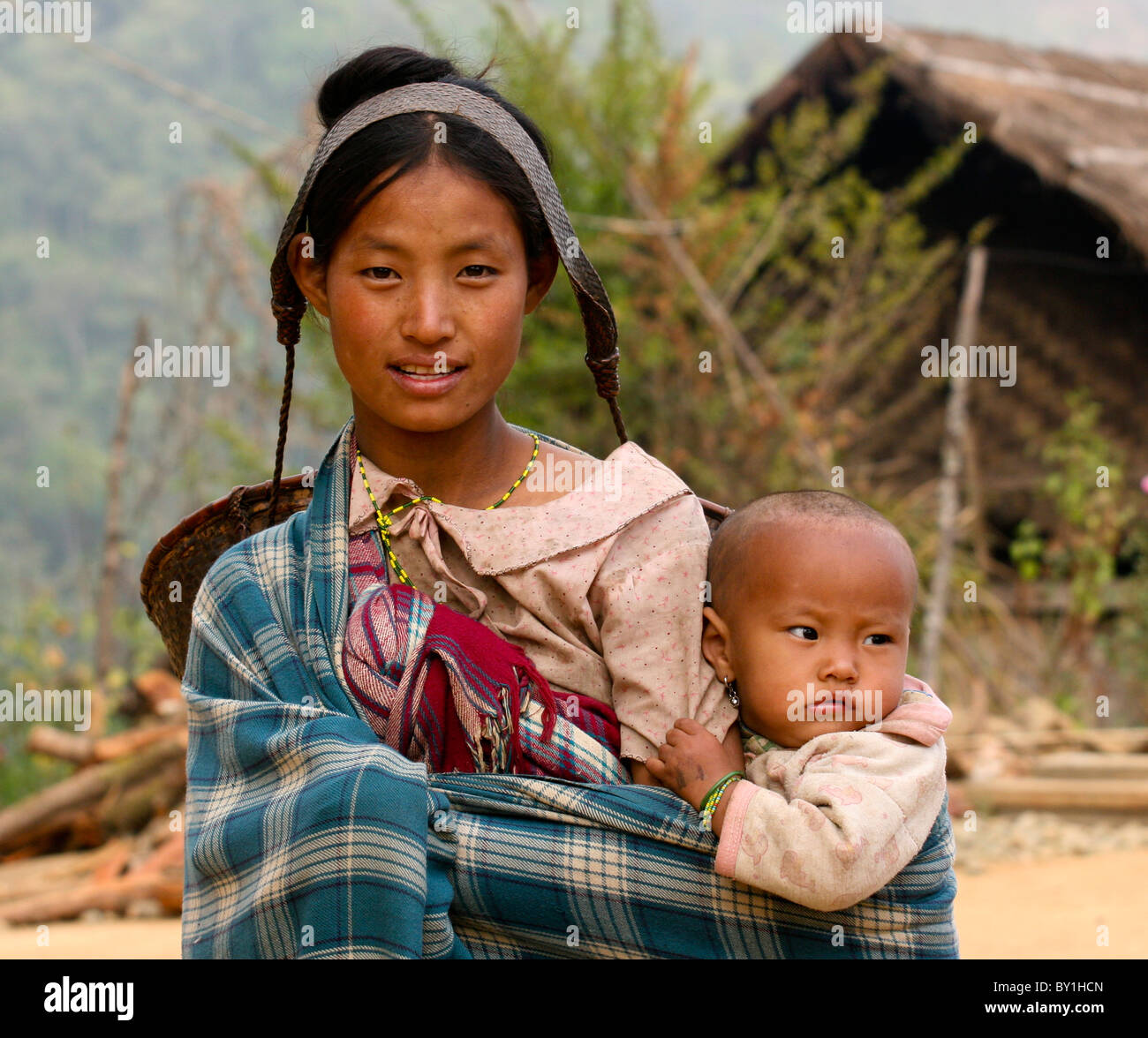 Myanmar Birmania, Naga Hills. Una giovane madre, con un tradizionale cestello di canna espulso dalla sua testa e il suo bambino in Leshi village. Foto Stock