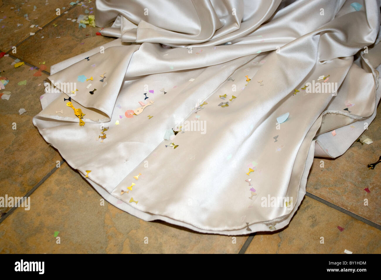 Abito da sposa il treno con i confetti sul pavimento in legno Foto Stock