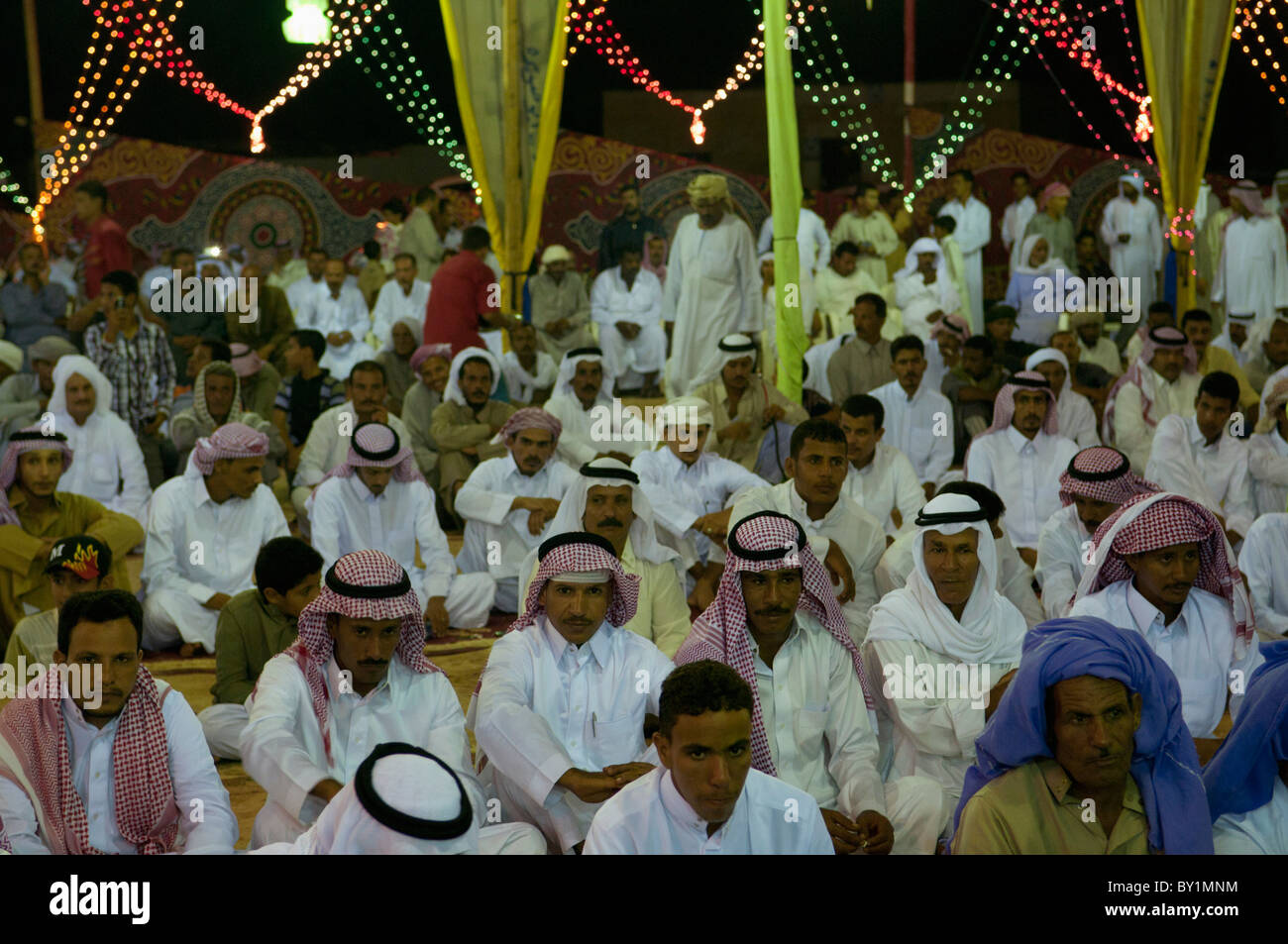 Ospiti seduti attendono intrattenimento durante un beduino tradizionale celebrazione di matrimonio. El Tur, Sinai, Egitto Foto Stock