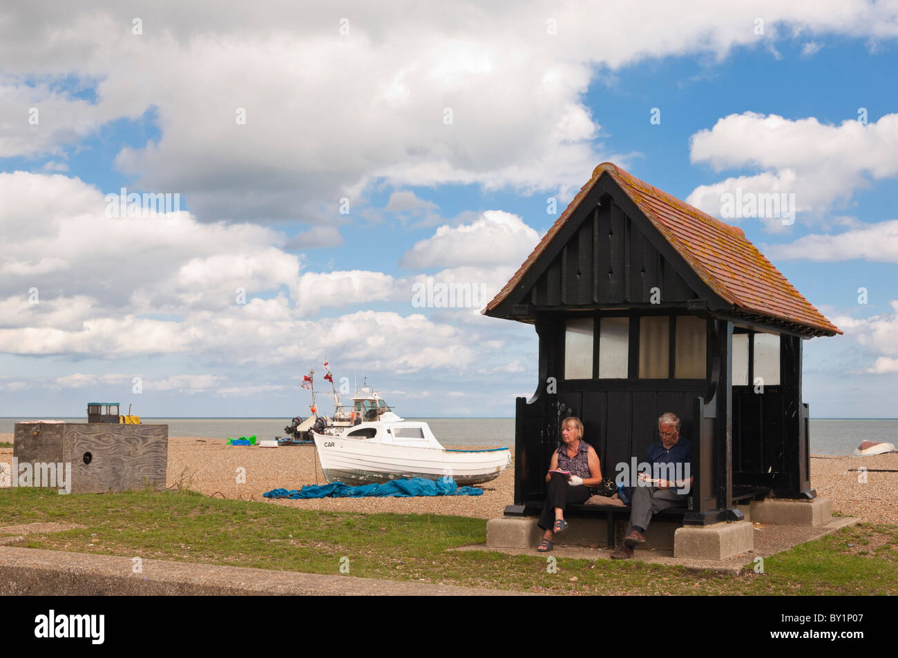 Un paio di rilassarsi sul lungomare in estate a Aldeburgh , Suffolk , Inghilterra , Gran Bretagna , Regno Unito Foto Stock