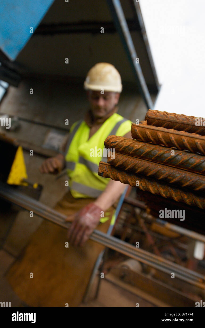 Il rinforzo del cemento armato: tondino di acciaio tagliati e piegati in fabbrica. Lavoratore piegatura di tondini di acciaio Foto Stock