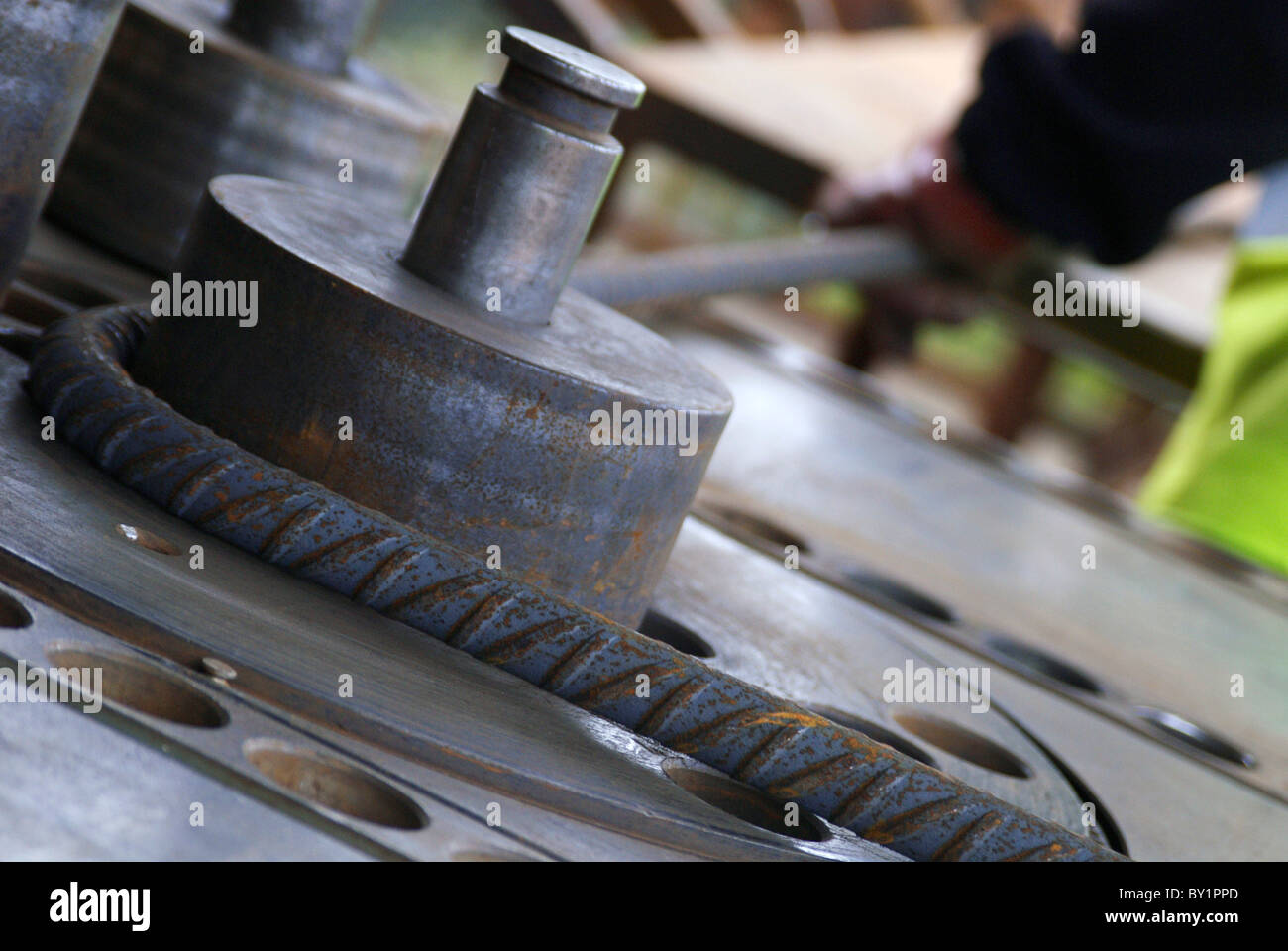 Il rinforzo del cemento armato: tondino di acciaio tagliati e piegati in fabbrica. Lavoratore piegatura di tondini di acciaio Foto Stock