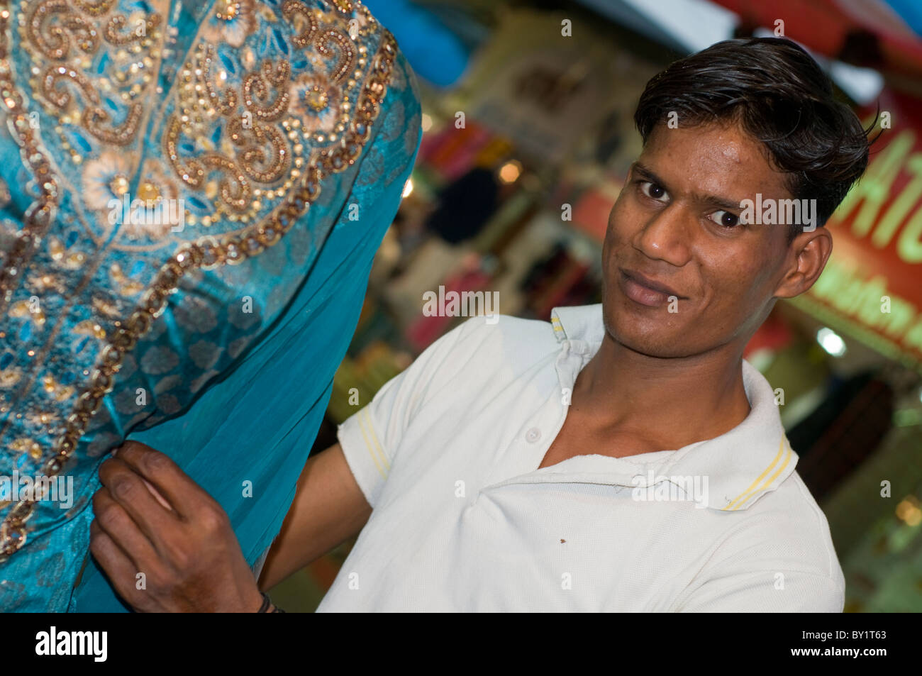 Un sarto tendente ad un sari su un mercato in stallo Bhopal, India Foto Stock