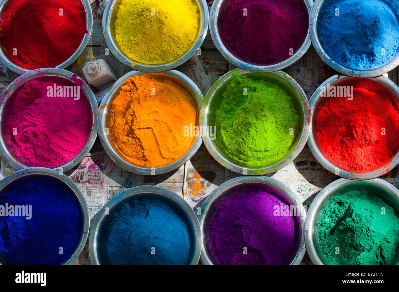 Guardando verso il basso sulla colorata di riso indiano in polvere in ciotole di metallo utilizzato per la realizzazione di disegni e modelli rangoli al festival. Andhra Pradesh, India Foto Stock