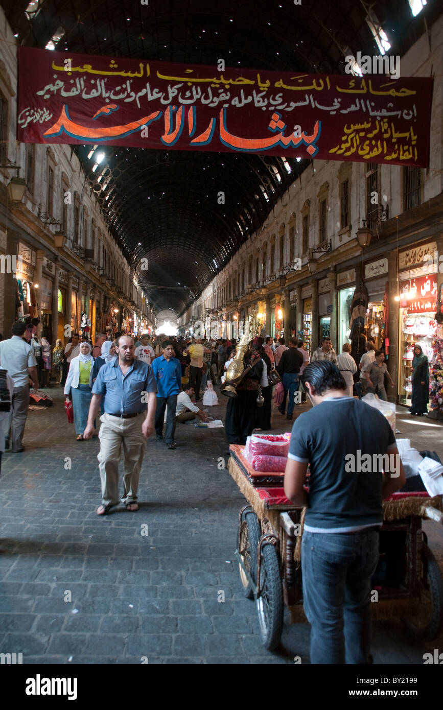Gli acquirenti siriano a piedi attraverso la trafficata e affollata al mercato Hamidiyah, un tipico mezzo souq orientale nella città vecchia di Damasco, Siria. Foto Stock