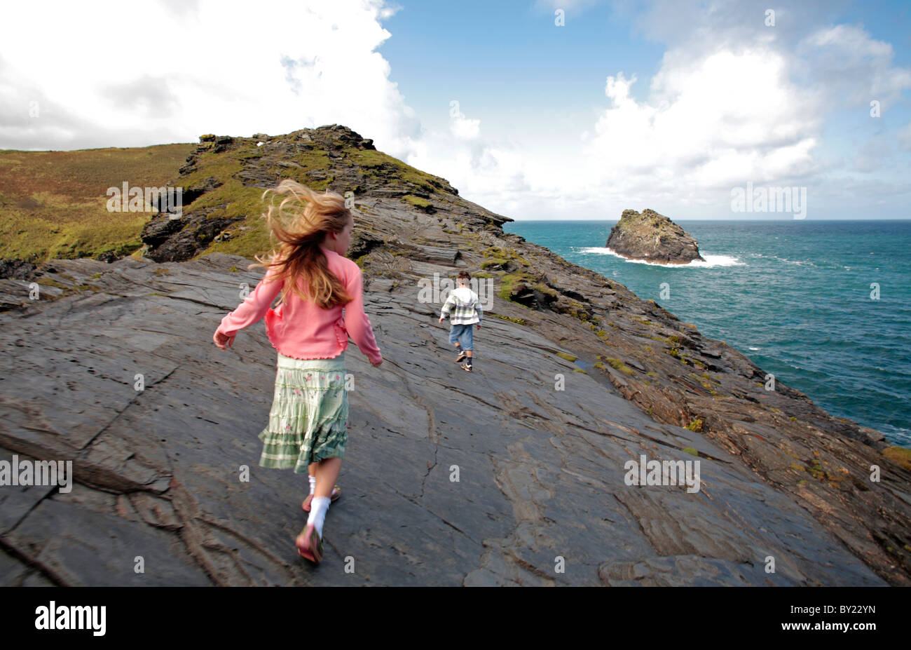 Inghilterra, Cornwall. Un ragazzo e una ragazza a piedi lungo clifftops verso penalmente punto in Boscastle. (MR) Foto Stock